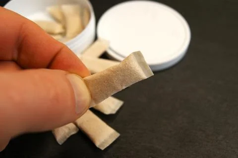 Close-up of picking up a nicotine pouch Stock Photos