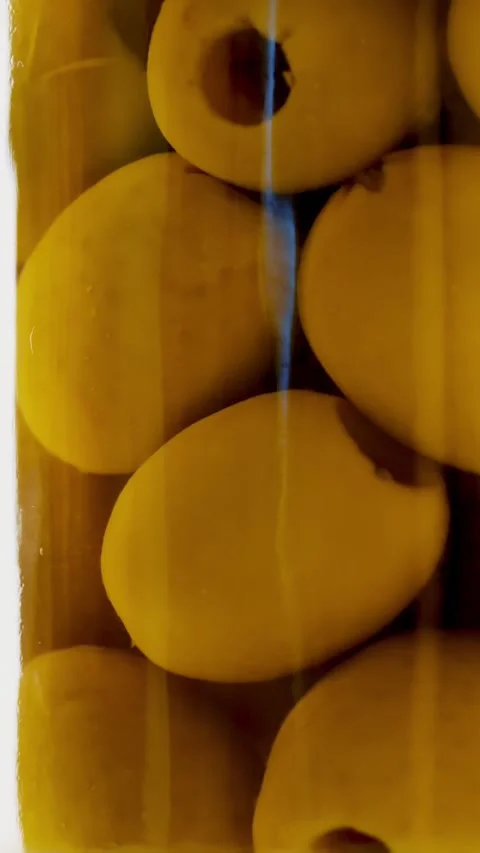 Close-up, pickled large green olives in a glass jar, food product rotate on Stock Footage 320611190