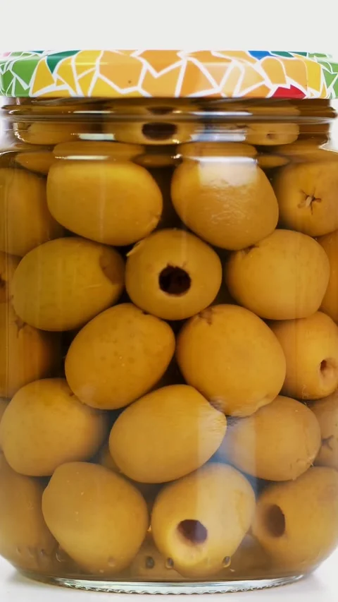 Close-up, pickled large green olives in a glass jar, food product rotate on Video stock 321754168