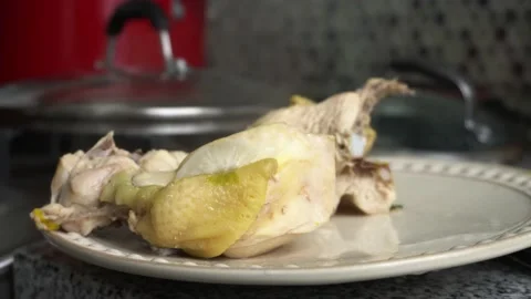 Close-up of a piece of boiled chicken steaming on a plate in the kitchen at Stock Footage 181774875