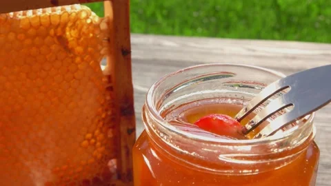 Close-up of the piece of ripe strawberry on the fork dipped into delicious honey Stock Footage 161163078