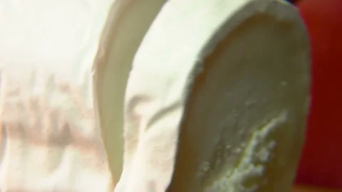 Close-up of a piece of Sainte Maure de Touraine goat cheese cut with a knife Stock Footage 136694534