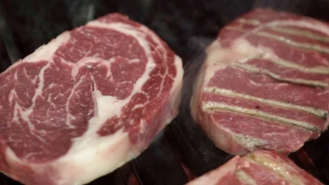 Close-up of pieces of red meat on grill. Action. Pieces of juicy marble meat are Stock Footage 108276339