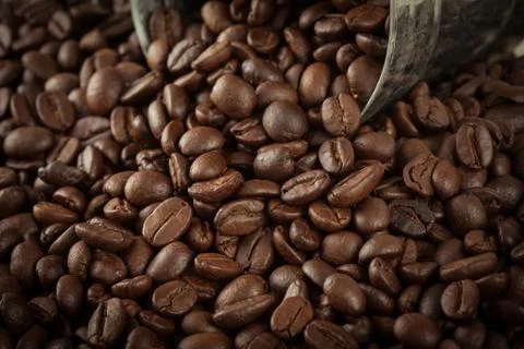 Close up pile of coffee bean pour out of the small silver tank with vintage c Stock Photos
