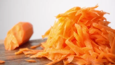 Close-up of a pile of grated carrots under a metal grater. Stock Footage 255665417