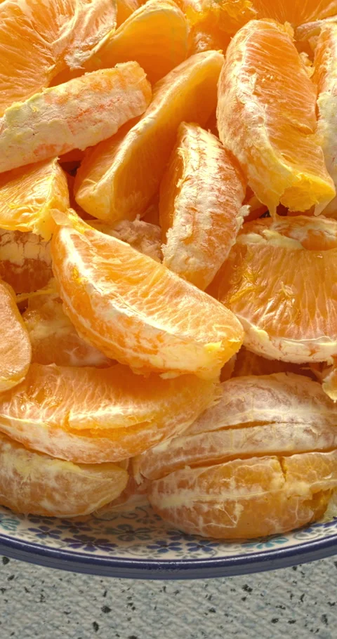 Close-up of a pile of orange segments on a plate. Vertical video. Vídeo Stock 334548977