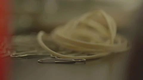 Close-up of pile of paperclips and rubber bands 库存影片 334050112