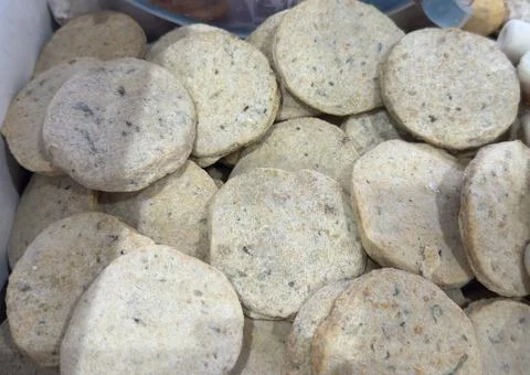 Close-up of a pile of round, light-colored, speckled bread rolls. Stock Photos