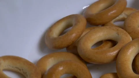 Close-up of a pile of small ring-shaped bread rolls rotating on a white pla.. Stock Footage 340070514