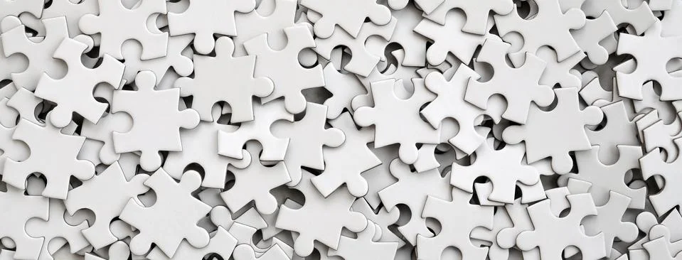 Close-up of a pile of uncompleted elements of a white puzzle. A huge number o Stock Photos