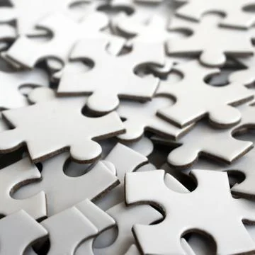 Close-up of a pile of uncompleted elements of a white puzzle. A huge number o 스톡 사진