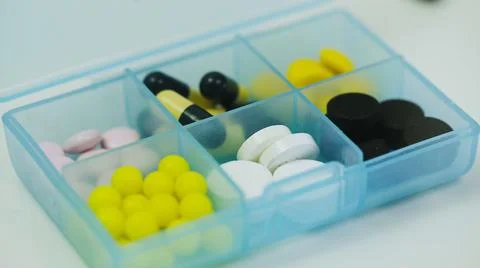 Close-up of a pillbox with different tablets in each cell 스톡 사진