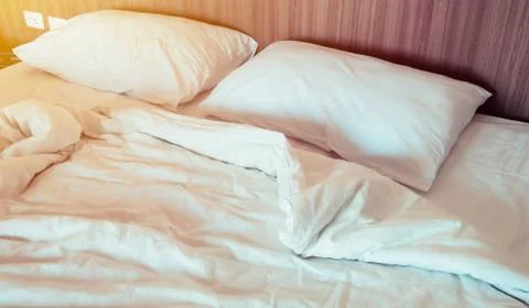 Close up of pillows on the bed after wake up with soft light morning. Stock Photos