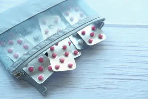 Close up of pills of blister pack in a small bag on blue background Stock Photos