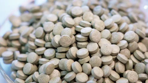 Close up pills dropping white background 50fps Video stock 156168009