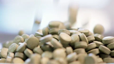 Close up pills dropping white background side shot 50fps Video stock 156168301