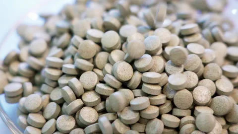 Close up pills dropping white background slow motion 100fps Video stock 156168396