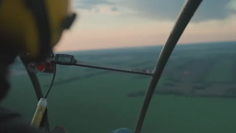 Close up pilot gripping paraglider frame against sunset sky over farmland Stock Footage 317176986