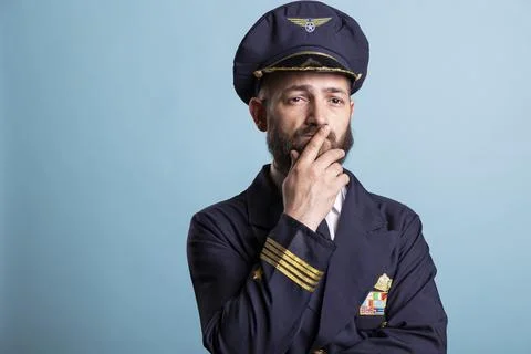 Close up of pilot thinking, rubbing lips with fingers and staring forward 写真素材
