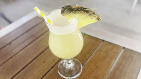 Close Up of Pina Colada Cocktail with Pineapple Garnish on Table Vídeos de archivo 342029931