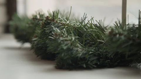 Close up of pine branch and cones in calm indoor setting with white surface with Stock Footage 347692997