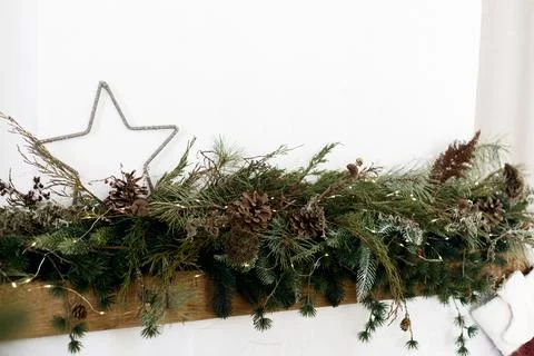 Close up of pine garland with pine cones, dried flowers, starand  lights on.. Stock Photos