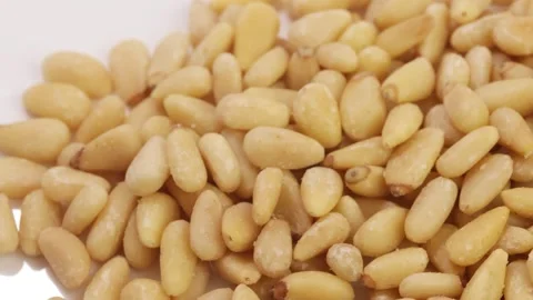 Close-up of pine nuts, isolated on a white background. Video stock 345816056