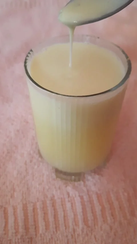 Close-Up of Pineapple Juice Stirring and Dripping from Spoon into Glass Stock Footage 333389051
