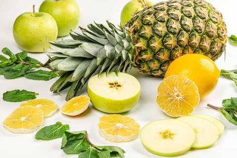Close-up, pineapple with lemon, apple and mint leaves Stock Photos