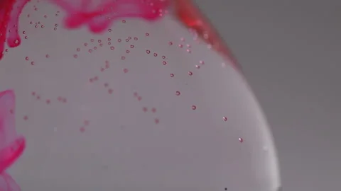 Close up of pink liquid going down throughout water on a flat bottomed flask Stock Footage 231488120