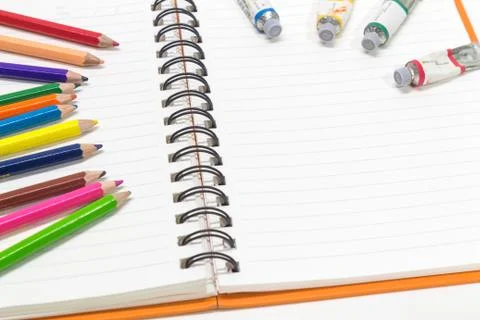 Close-up of pink orange note book and colored pencils, water colors Stock Photos