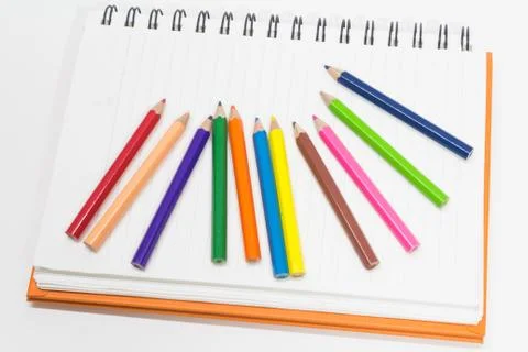 Close-up of pink orange note book and colored pencils, student drawing Stock Photos