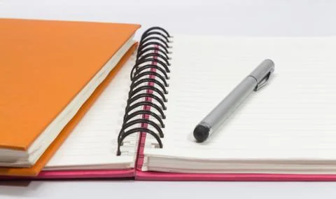 Close-up of pink, orange open note book and pen Stock Photos