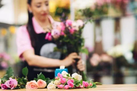 Close-up of pink roses lying on a table in a flower shop, from which the florist Stock Photos