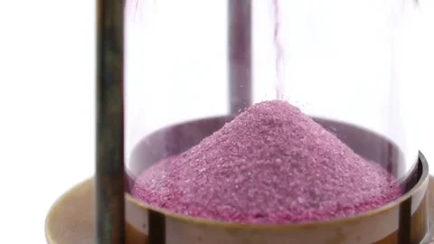 Close-up of Pink Sand Slowly Falling in Hourglass Stock Footage 310817411