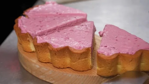 Close-up of a pink strawberry pie being precisely sliced, highlighting its cream Stock Footage 337751207