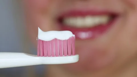 Close-up of pink toothbrush with white toothpaste ready for brushing teeth Stock Footage 340261255