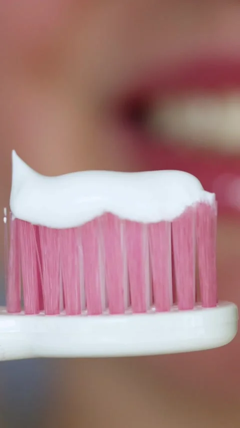 Close-up of pink toothbrush with white toothpaste ready for brushing teeth Stock-Footage 343838146