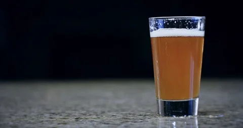Close up of a pint of beer sliding on a bar 4k Stock Footage 104456933