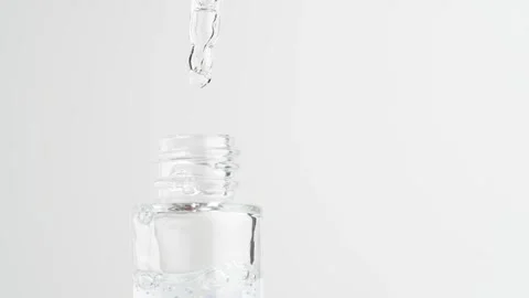 Close up of pipette and the transparent serum with blue granules in bottle... Stock Footage 260318341