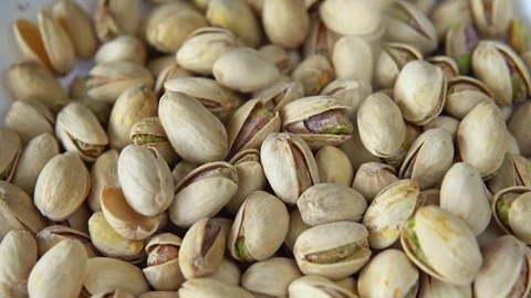 Close-up of pistachio nuts rotating on the table Stock Footage 114104669