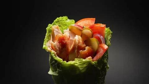 Close-up of pita bread wrapped in a green lettuce leaf and delicious filling Stock Footage 236816800