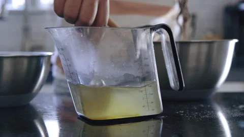 Close on pitcher as liquid ingredients are stirred with a spoon slow motion Video stock 194461854