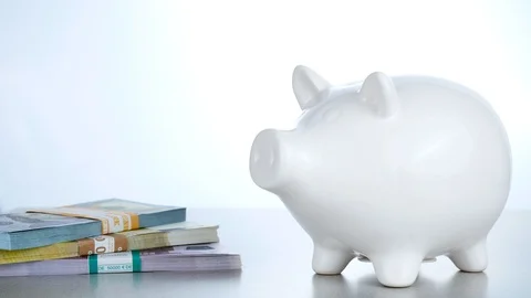 Close up of pitting cryptocurrency into white pig moneybox Stock Footage 88783669