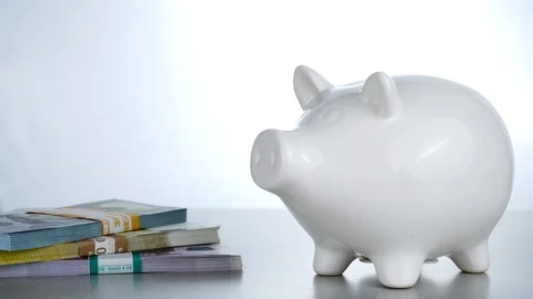 Close up of pitting Litecoin cryptocurrency into white pig moneybox Stock Footage 88783341