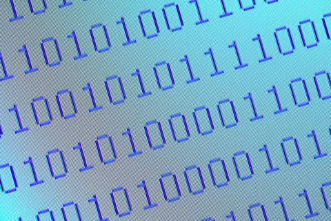 Close-up of pixelated binary numbers on computer screen 库存照片