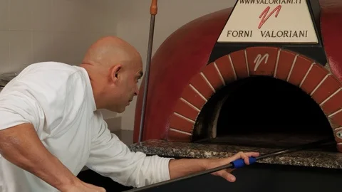 Close up of pizza baker cleaning oven  Stock Footage 86897399