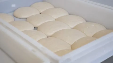 Close-up of pizza dough balls with flour in a container in the pizzeria kitchen. Stock Footage 307388325