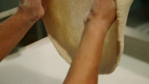 Close up pizza dough tossed and stretched in restaurant kitchen, slow motion Stock Footage 229808903
