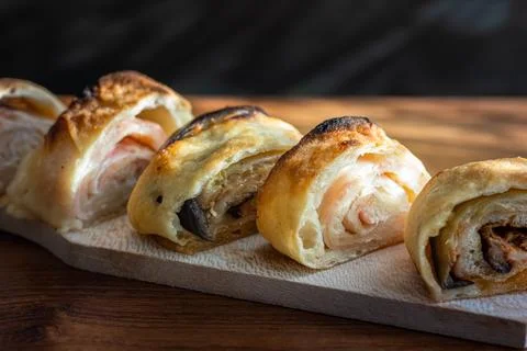 Close up on pizza rolls on the brown table with sunlight Stock Photos